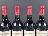 three bottles of red wine are lined up on a table