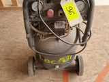 a small air compressor sitting on the floor in the garage