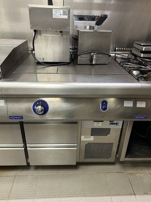 une grande cuisine en inox équipée de nombreux appareils électroménagers
