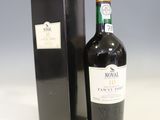 une bouteille de vin posée à côté d'une boîte noire