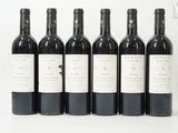 six bouteilles de vin sont alignées sur une surface blanche