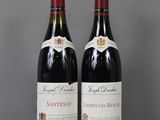 two bottles of wine sitting on top of a table next to each other