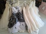 de nombreuses robes de mariée suspendues à un portant