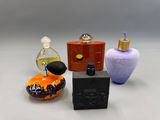 trois flacons de parfum différents posés sur une surface blanche