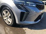 the front end of a silver car parked on the side of the road