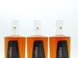 trois bouteilles de whisky posées les unes à côté des autres sur une surface blanche