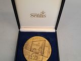 un gros plan sur une médaille d'or dans un coffret posé sur une table