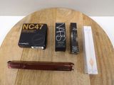a wooden table with a pen, pencil, and a box on it