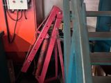 une échelle rouge posée à côté d'un escalier bleu et orange