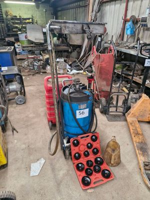 une machine bleue et rouge dans un garage, à côté d'autres outils