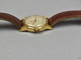 an image of a gold watch with a brown leather strap