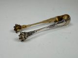 une paire de cuillères en argent ornées de fleurs, posées sur une table