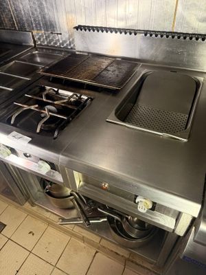 a large stainless steel stove top in a commercial kitchen