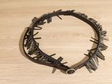 a picture of a necklace with spikes on a wooden surface