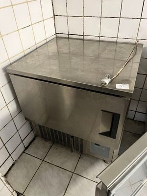 un lavabo en acier inoxydable dans un coin d'une salle de bains carrelée
