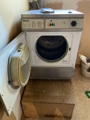 une image représentant une machine à laver et un chat dans une pièce