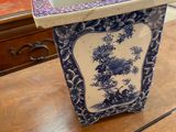 a blue and white flower pot on a wooden table