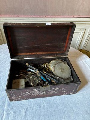 une boîte en bois remplie d'objets divers, posée sur une table