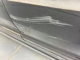 a black car with a broken door and a broken window handle