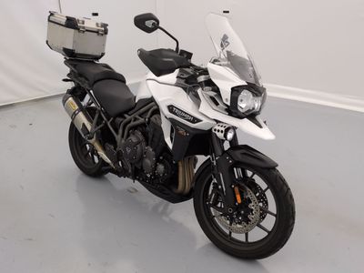 une moto blanche garée dans une pièce aux murs blancs