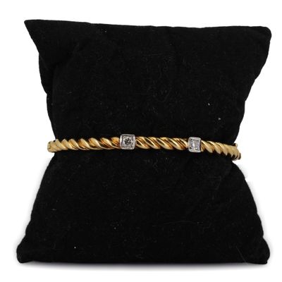 un bracelet en or et diamants posé sur un coussin de velours noir