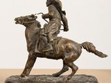 statue of a man riding a horse on a wooden table