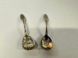 pair of silver spoons sitting on top of a white surface