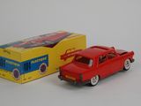 a red toy car next to a yellow box on a white surface