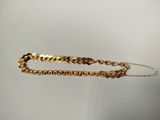 a close up of a pair of gold bracelets on a white surface