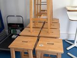 plusieurs tabourets en bois posés sur un tapis bleu devant un ordinateur portable