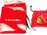 a red bag with a pair of gold shoes on it