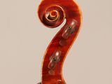 an antique violin with a scroll on the back of it