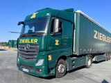un camion vert garé sur un parking