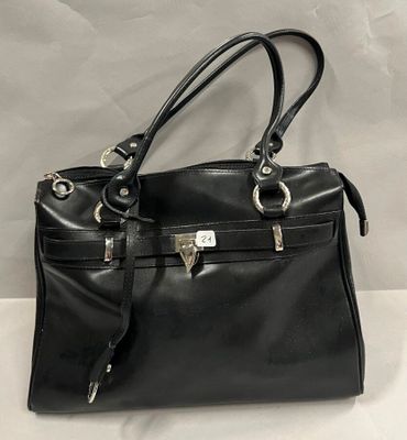 un sac à main en cuir noir posé sur une table blanche, sur fond blanc