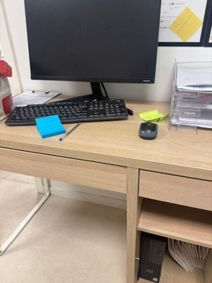a desk with a computer, keyboard, mouse, and other items on it