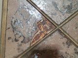 a reflection of a person in a mirror on a tiled floor