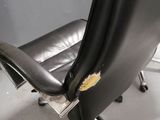 a black leather office chair with a gold emblem on the back