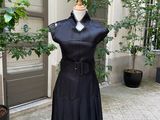 une robe noire posée sur un mannequin dans une cour