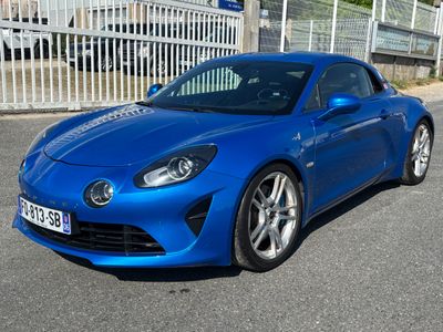 une voiture de sport bleue garée devant une clôture