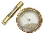 une horloge dorée et un stylo posés sur une surface blanche