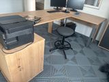 a printer sitting on top of a wooden desk in an office