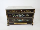 une commode noire et dorée décorée de fleurs peintes