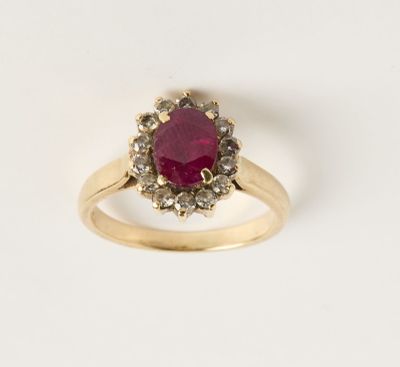 un gros plan d'une bague en or sertie d'un rubis entouré de diamants blancs
