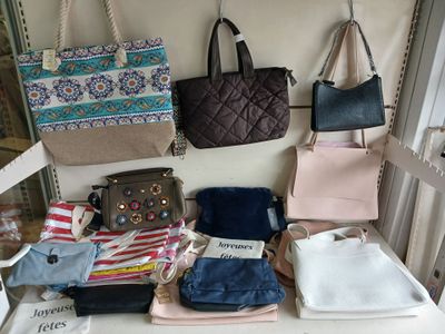 de nombreux sacs et sacs à main posés sur un banc blanc