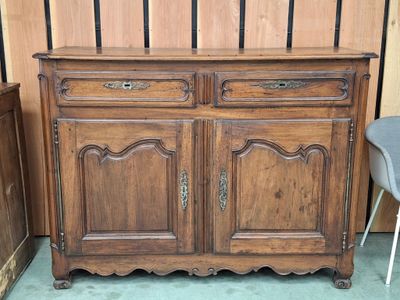 une armoire en bois à deux portes, devant laquelle se trouve une chaise