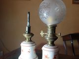 deux lampes posées sur une table, avec des tableaux accrochés au mur