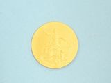 a yellow coin sitting on top of a blue surface