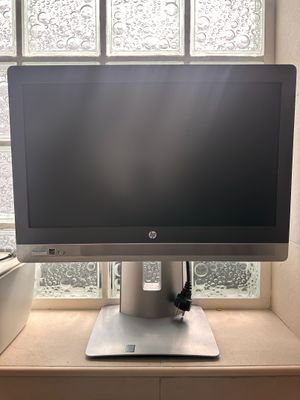 a computer monitor sitting on a desk in front of a window