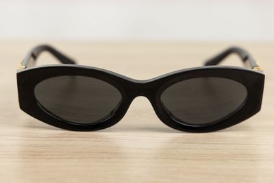 black cat eye sunglasses on a wooden table with a white background