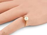 an image of a woman ' s hand with a pearl ring on it ' s finger